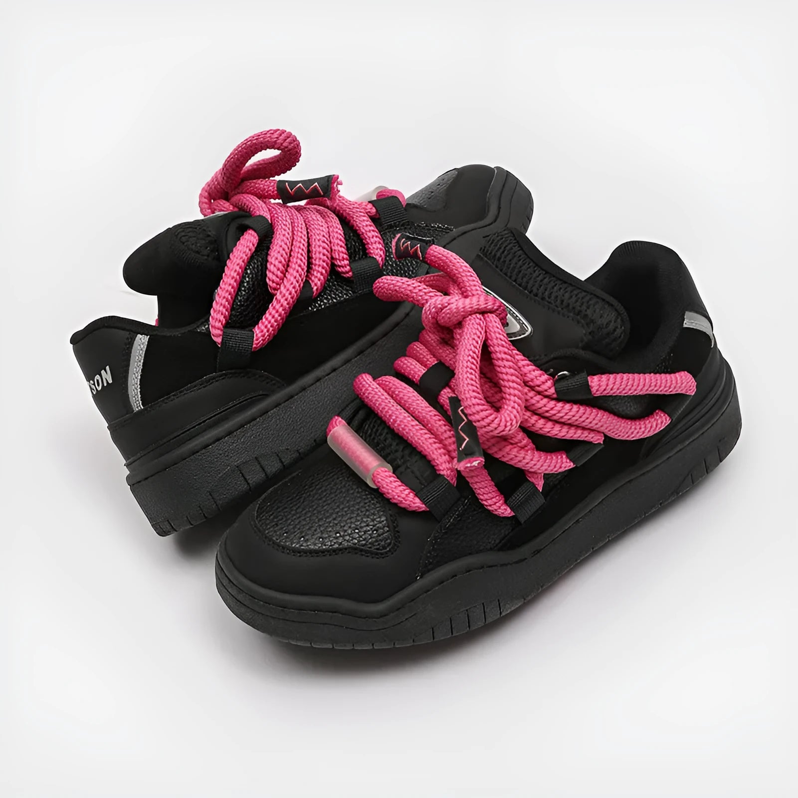 Pair of low-top unisex casual sneakers with thick flat rubber sole and lace-up front in a solid colour.