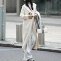 Long grey knitted cardigan coat with long sleeves on a hanger.