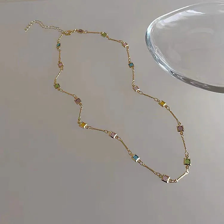 Square colour geometric alloy clavicle chain necklace with artificial crystal detail in gold tone.