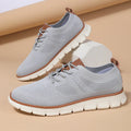 Men's grey and black mesh fabric casual sneakers with a round toe and low heel on a plain background.