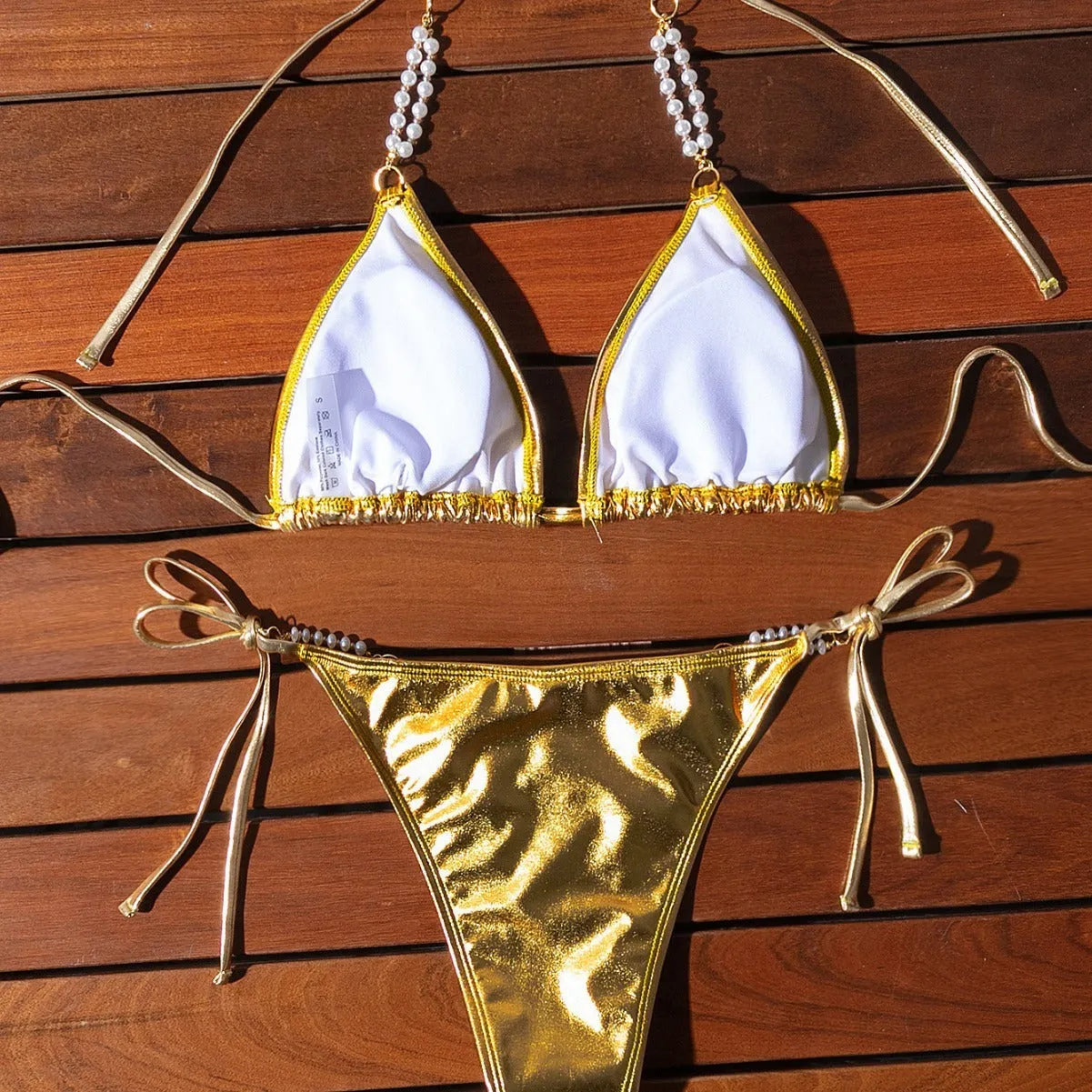Gold halter lace-up bikini with pearl chain detail on mannequin showing front view