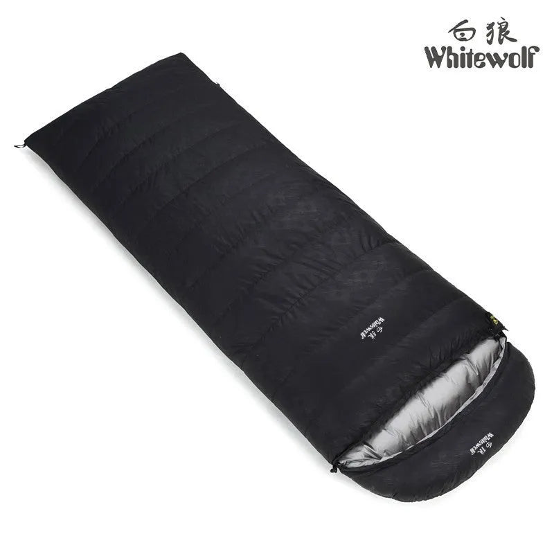 Black outdoor sleeping bag with thick goose down fill on a grassy campsite.