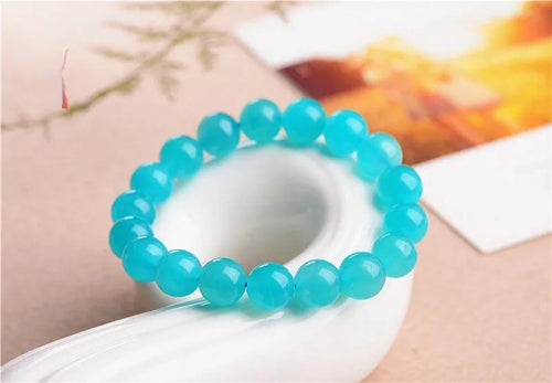 Loose natural blue-green Amazonite beads in various sizes from 6mm to 13mm on a white surface.