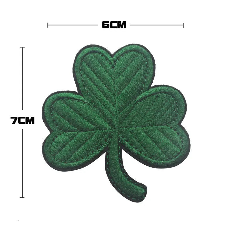 Outdoor embroidered fabric badge with Velcro backing on a green clover design.