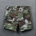 Man wearing loose-fitting solid colour cotton shorts with a zip fly and straight legs.