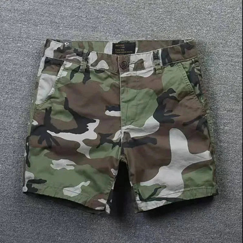 Man wearing loose-fitting solid colour cotton shorts with a zip fly and straight legs.