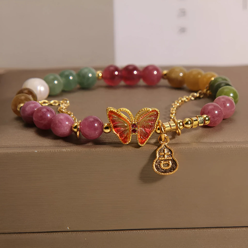 Natural jade coloured agate bracelet with a butterfly gourd tourmaline charm on an elasticated cord.