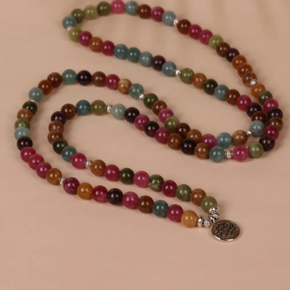 108 bead multi-layer bracelet in tourmaline colour with alloy details on a wrist.