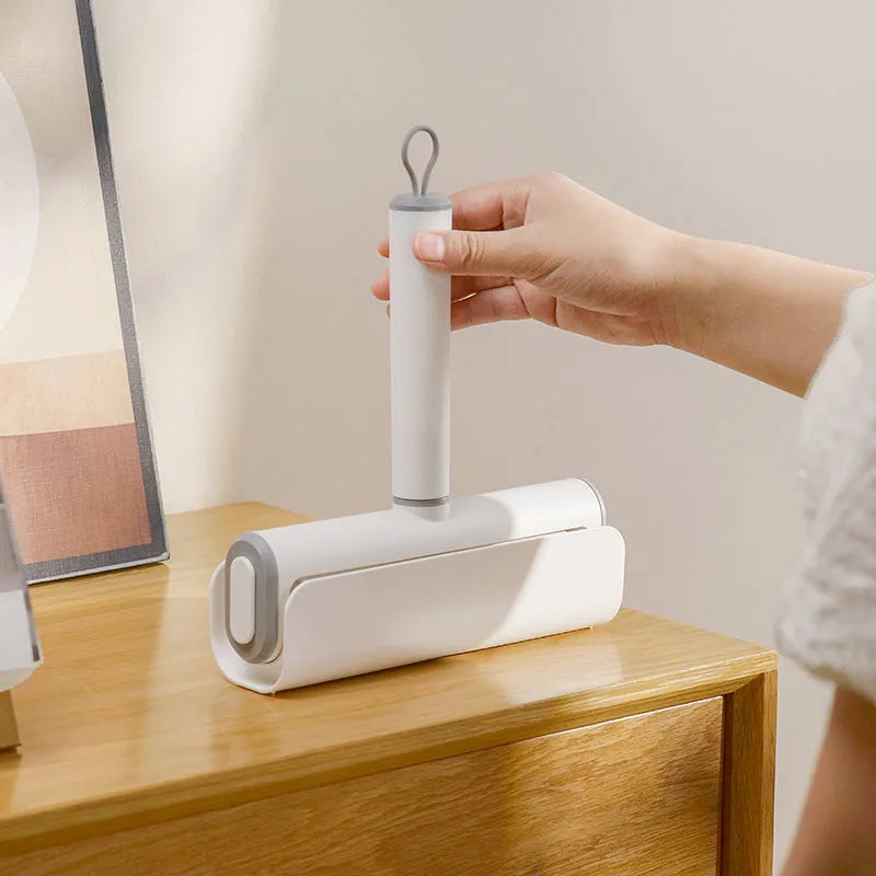 Lint remover roller with plastic handle and tearable paper roll for removing pet hair and dust.