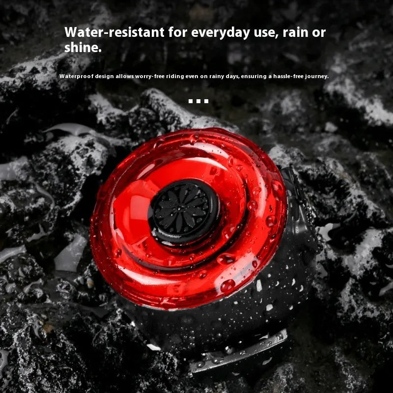 Round red bike warning light mounted on bicycle handlebar with silicone strap for night riding safety