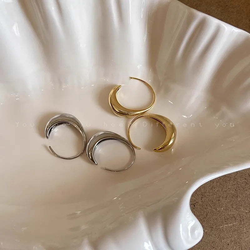 Teardrop hoop earrings in gold or silver tone alloy with C-shaped geometric design, one pair