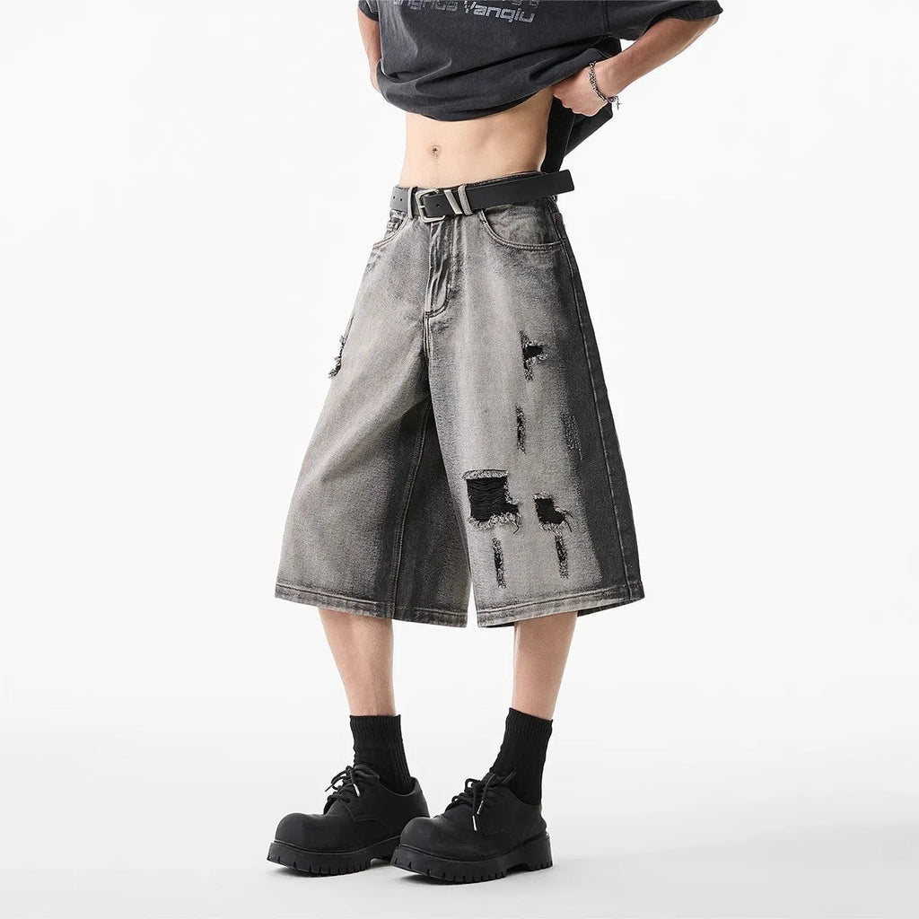 Grey women's denim shorts with water washed finish and hole distressing, loose cropped fit