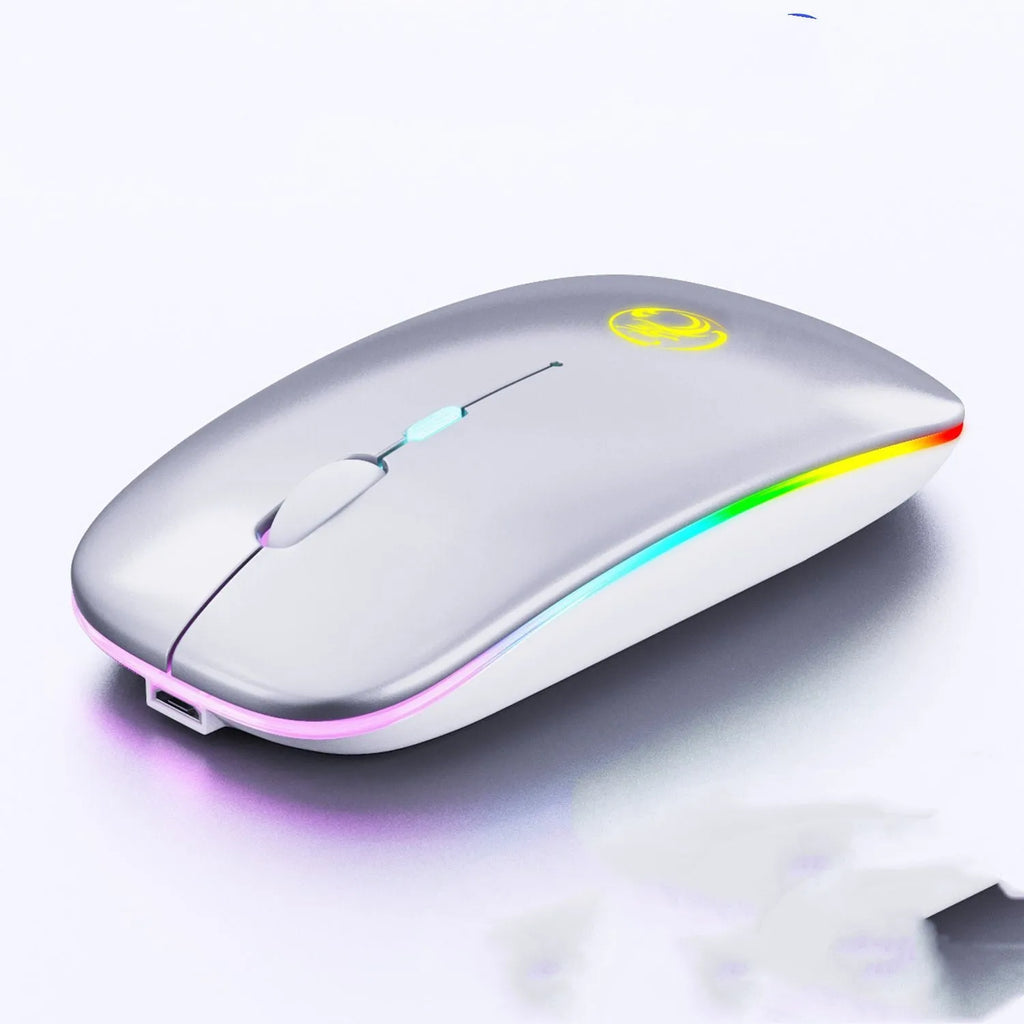 White dual-mode wireless mouse with silent buttons on a wooden desk next to a laptop.