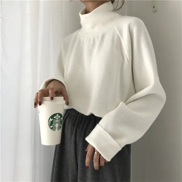 Women's apricot coloured half-high collar long sleeve loose fit top on a hanger