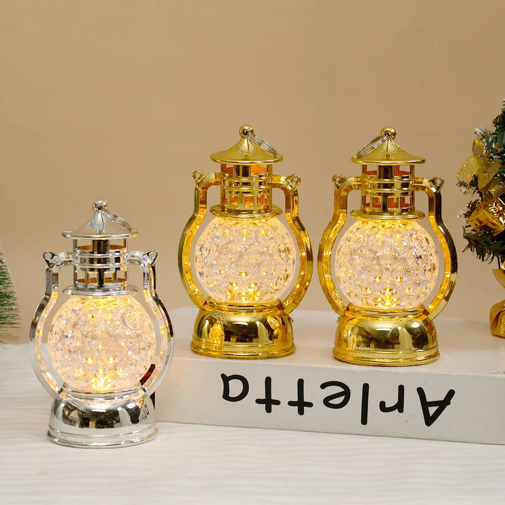 Small retro-style oil lamp LED night light in gold or silver finish on a table.