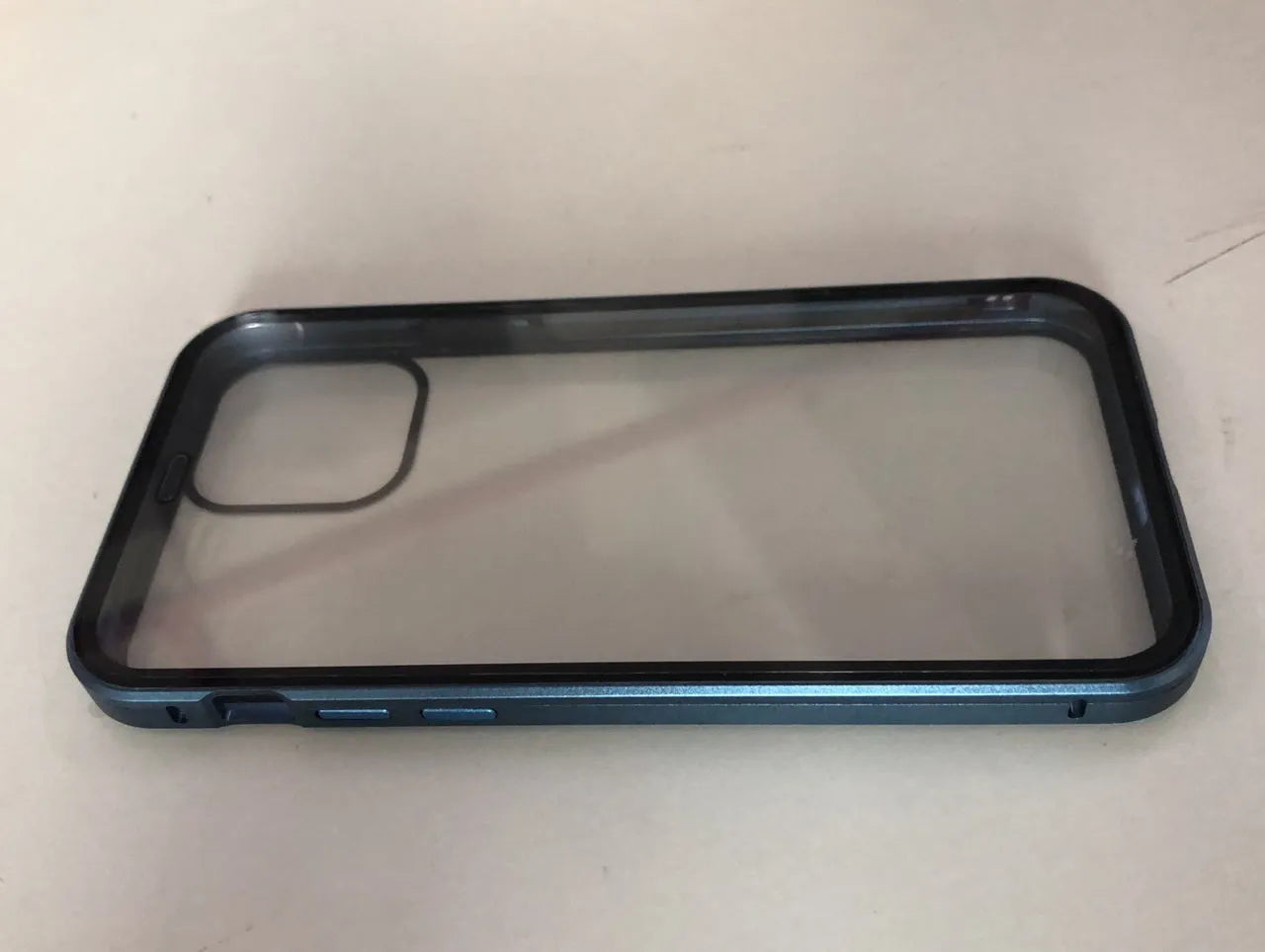 A closed clamshell phone case in blue glass with a geometric pattern, next to an iPhone showing the narrow viewing angle when open.