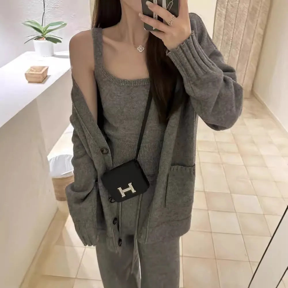 Women's light brown wool blend knit cardigan, vest, and trousers three-piece set laid flat.