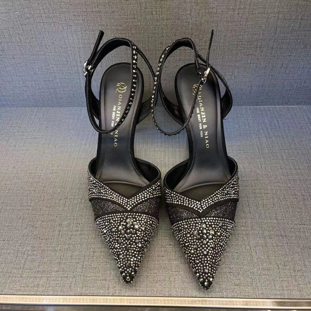 Women's black high heels with hollow red stiletto heel and pointed toe.