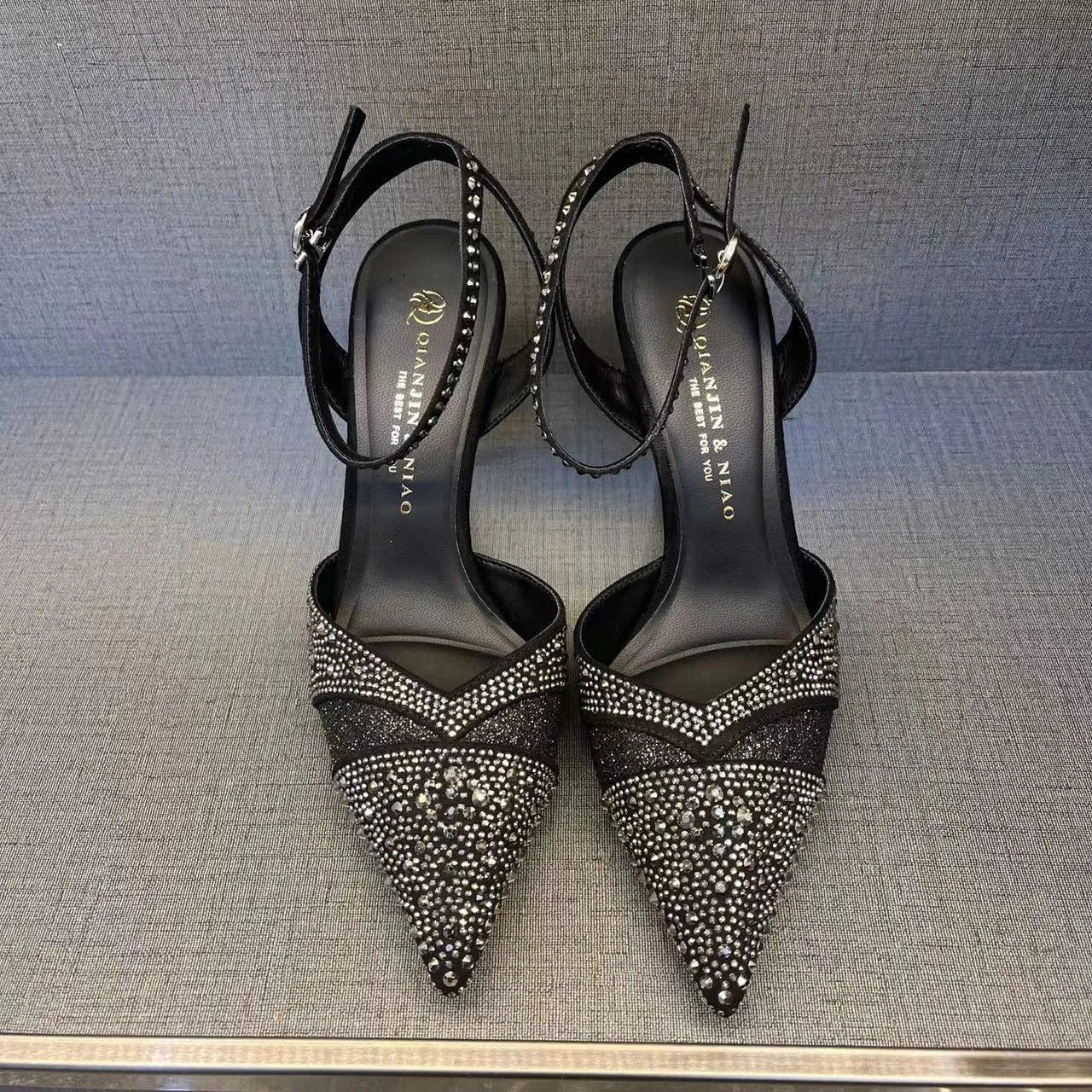 Women's black high heels with hollow red stiletto heel and pointed toe.