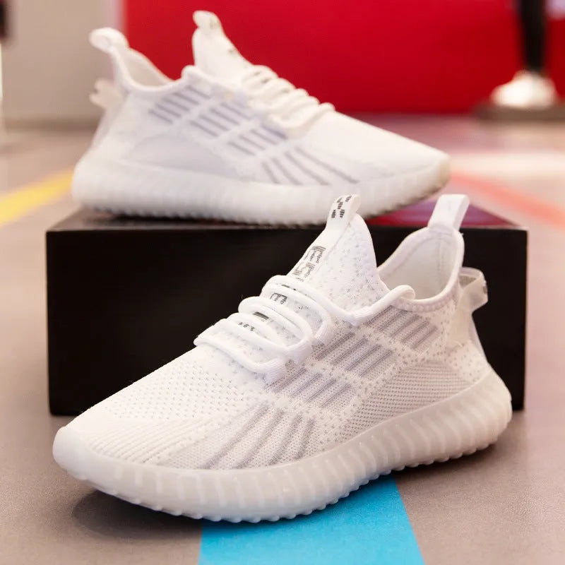 Men's white breathable flying fabric sports shoes with mesh lining and low upper design on a plain background.