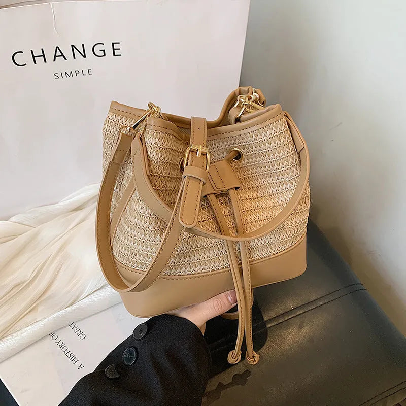 Brown woven straw women's crossbody bucket bag with horizontal square shape and adjustable strap