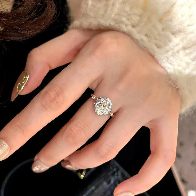 Close-up of a silver women's ring with an adjustable geometric band and a large oval bridal bouquet style diamond cluster.