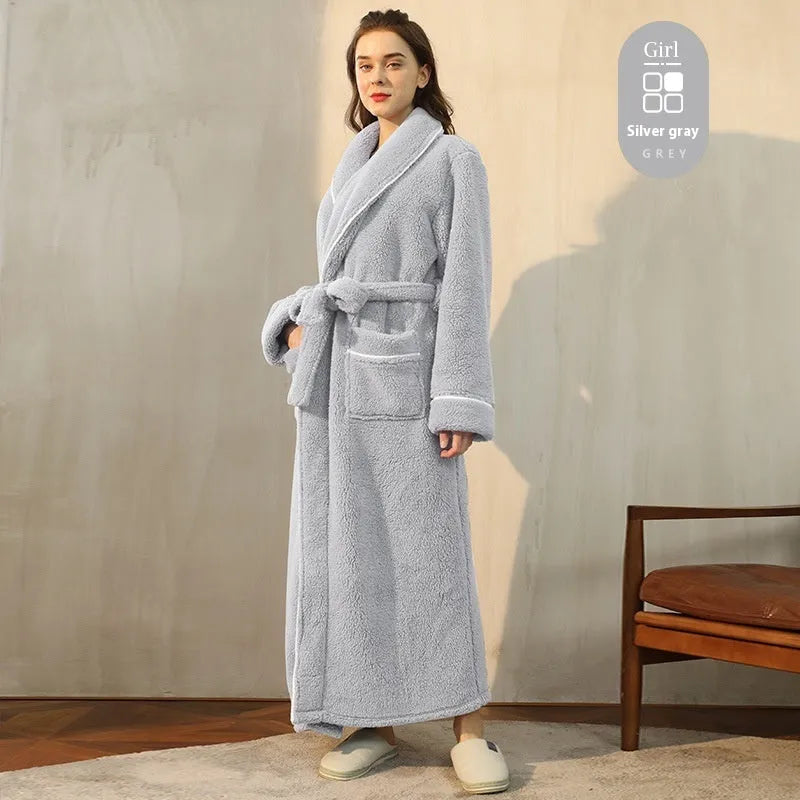 Man and woman wearing matching thick navy blue flannel bathrobes, showcasing the extended length and winter fabric.