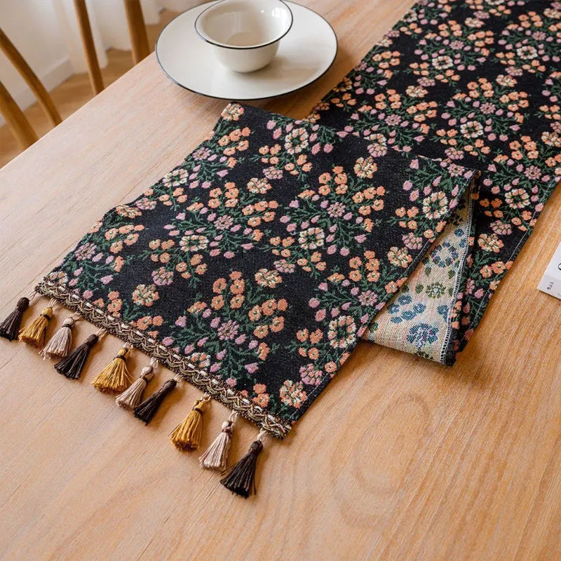 Dark blue Nordic stripe pattern jacquard table runner with tassel detail on a wooden table.