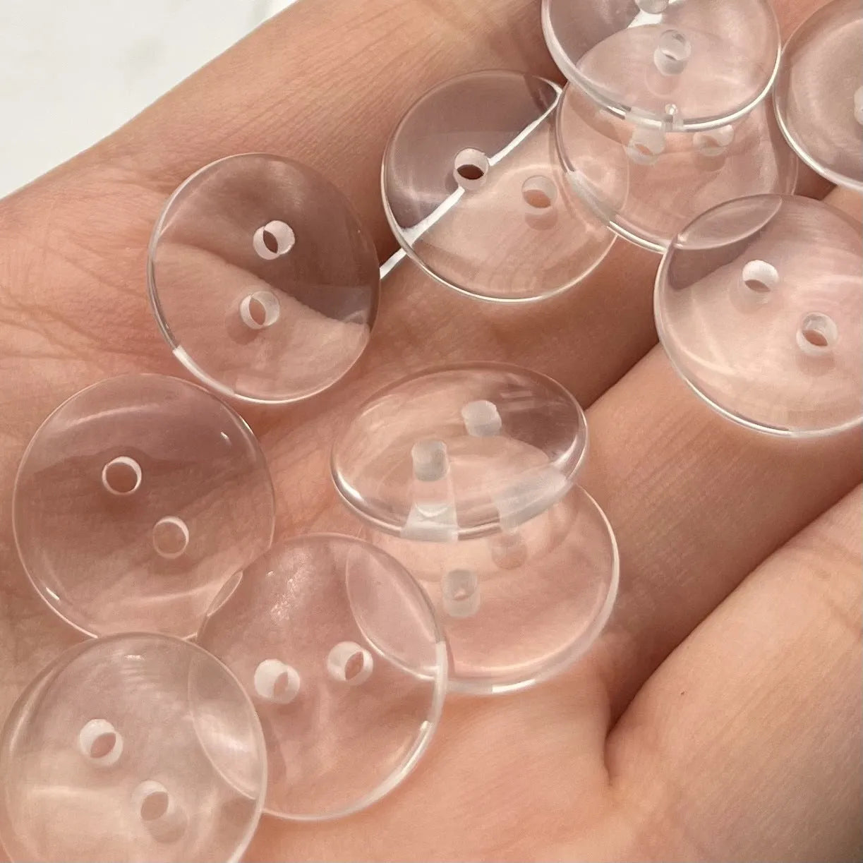 Transparent two-eye resin button 10mm on white background