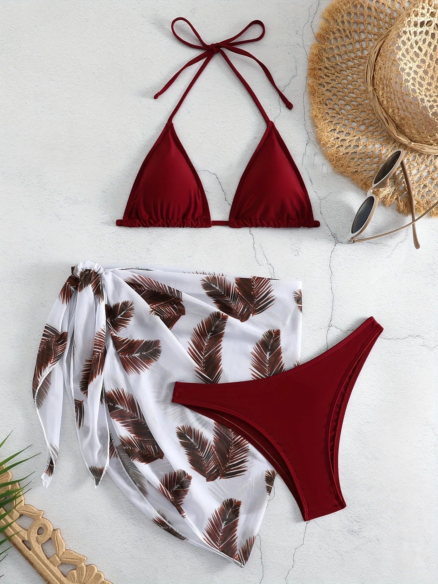 Women's orange polyester bikini set with a matching printed gauze skirt laid flat.