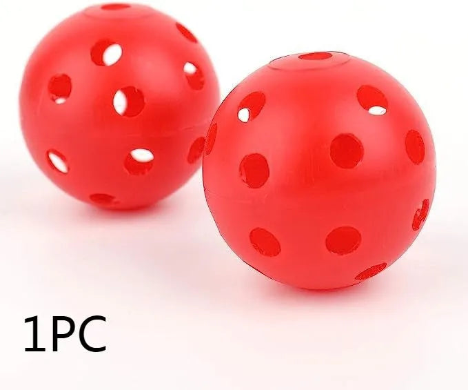 Multi-colour golf practice balls with 26-hole design on green grass, showing red, blue, green, yellow, orange, and white variants.