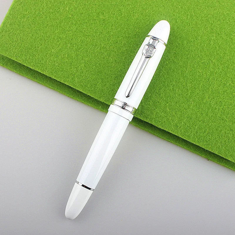Metal ball pen with pearl beads, black body and silver clip, lying on a desk