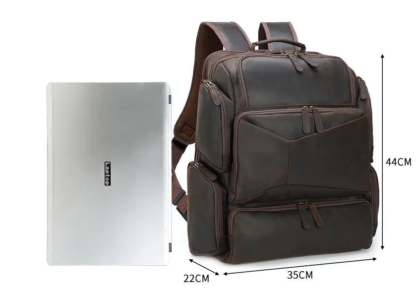 Dark brown men's leather backpack open to show internal compartments for a 17-inch laptop and organisation pockets.