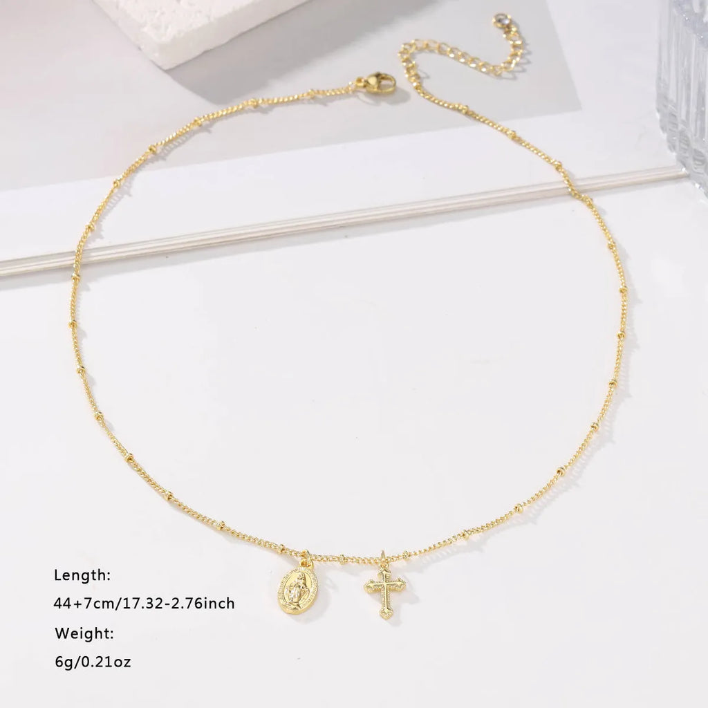 Geometric gold cross Virgin Mary pendant necklace on a chain with a lobster clasp.