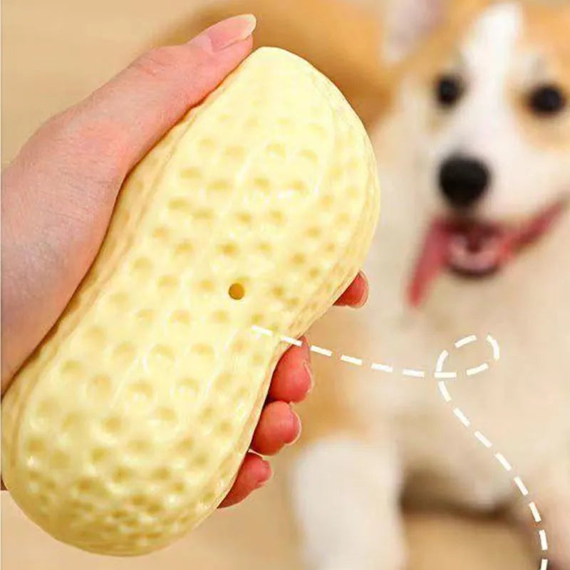 Yellow TPR peanut-shaped squeaky chew toy for dogs on a plain background.