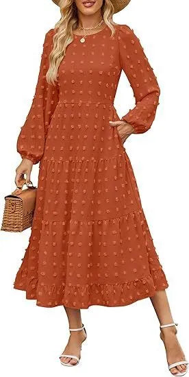 A woman wearing a beige high-waist long sleeve dress with ruffle detailing on the sleeves.