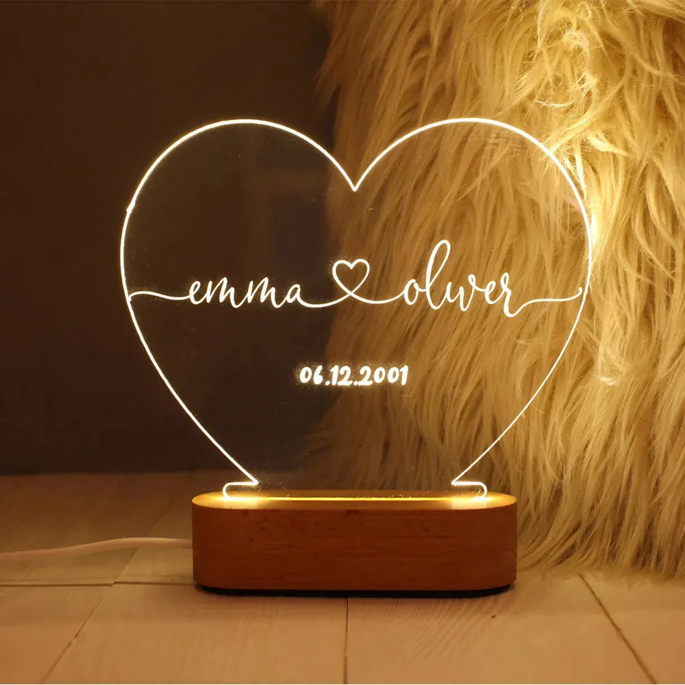 Custom clear acrylic night light displaying personalised names and date, lit by an LED base.
