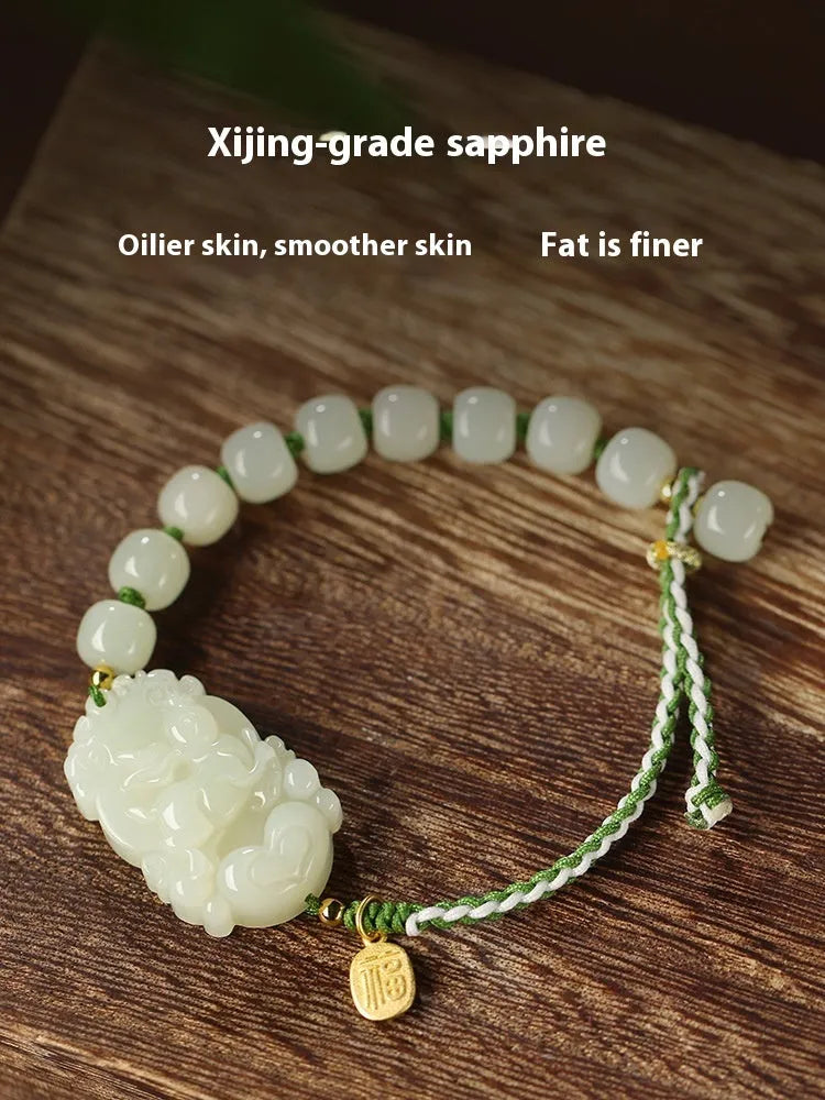 Hetian Jade Zodiac Bracelet on wrist showing rabbit charm, silver card, and red ice cotton rope.