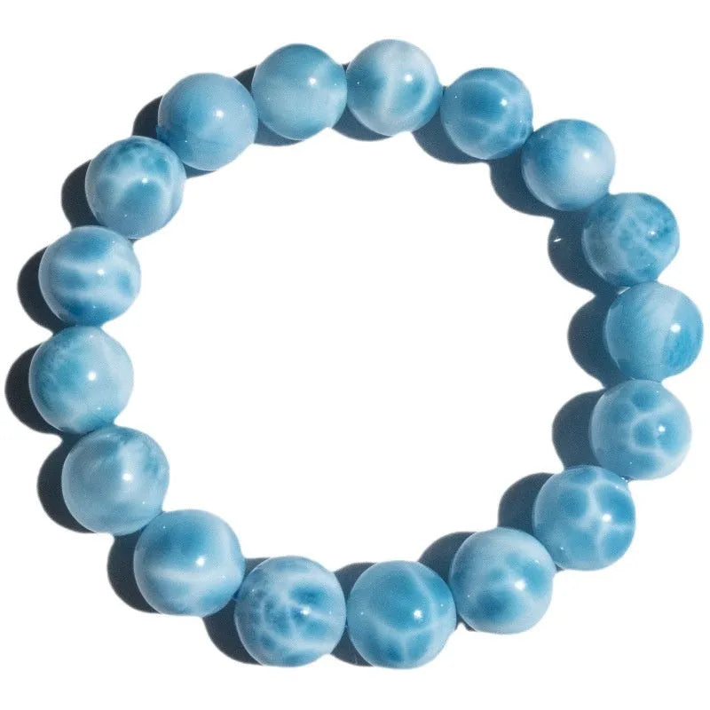 Blue natural crystal sea-pattern stone and Bodhi bracelet with pearl details on a white background.