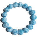 Blue natural crystal sea-pattern stone and Bodhi bracelet with pearl details on a white background.