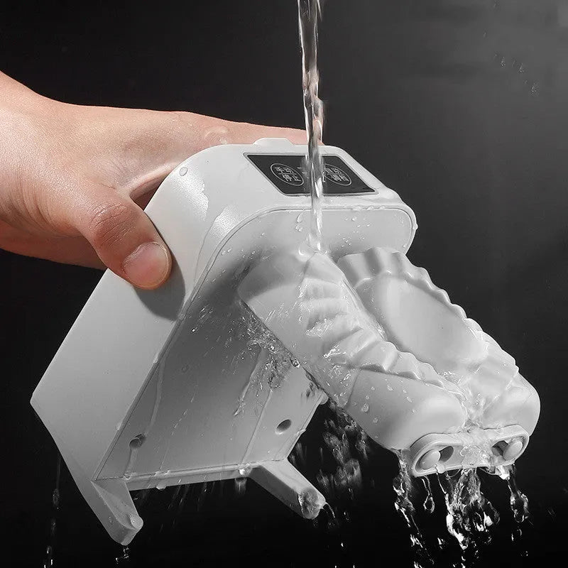 White automatic electric dumpling maker machine with USB cable, brush, and spoon on a kitchen counter.