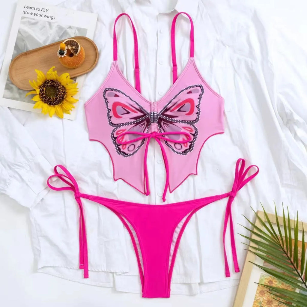 Women's purple split bikini swimsuit with bow detailing on the front, showing sleeveless top and briefs.