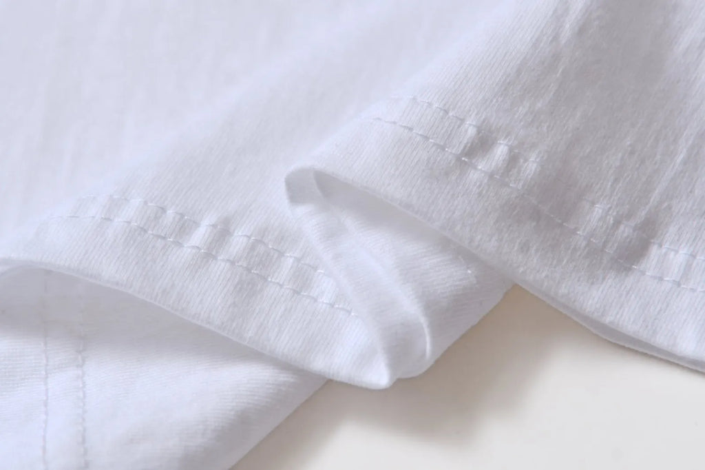 White cotton t-shirt overalls with short sleeves and a loose pullover fit