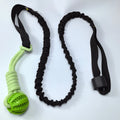 Green cotton thread dog tug toy with a ball on a rope for biting and interactive play.