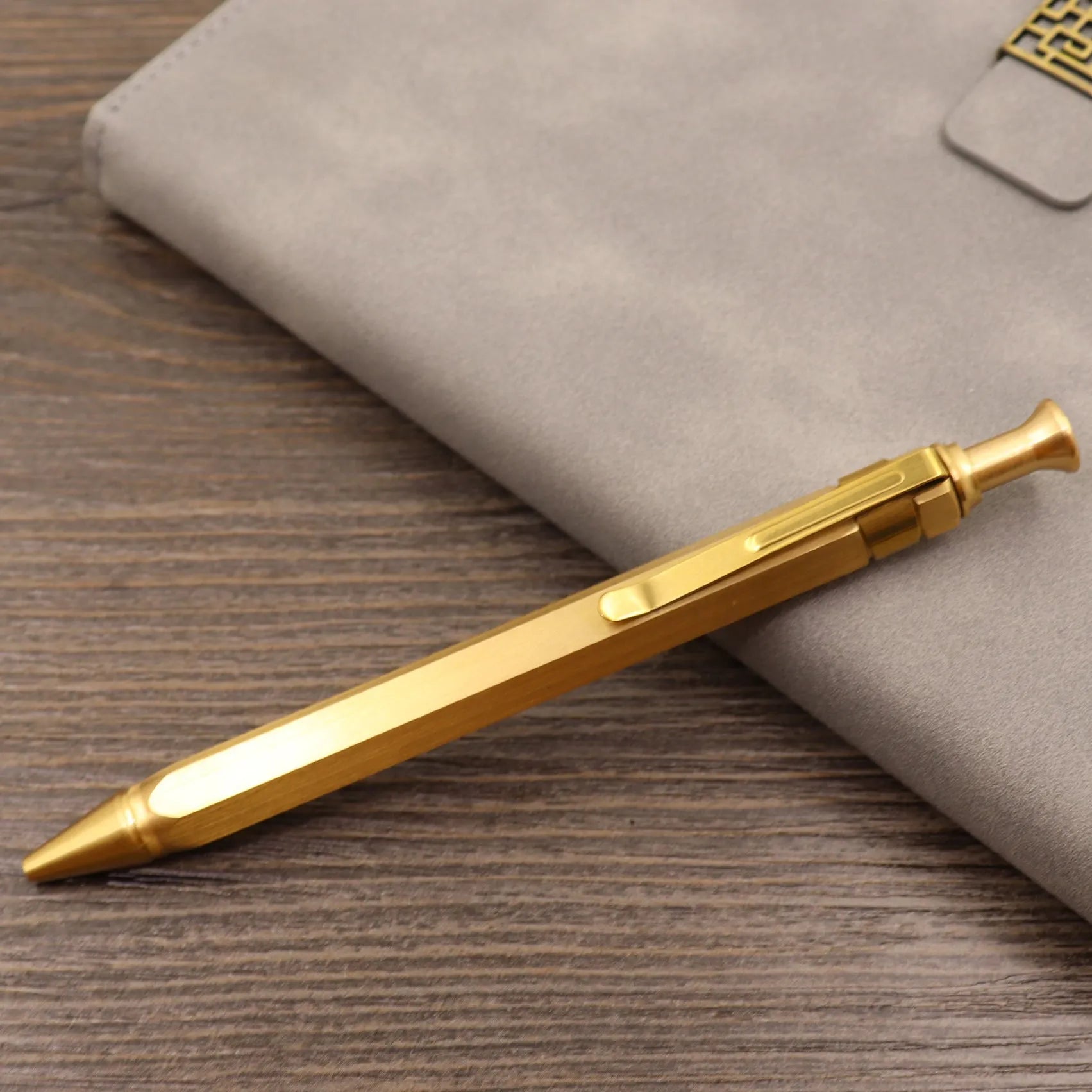 Brass tactical pen with six-ring press mechanism and cylindrical design in metallic finish