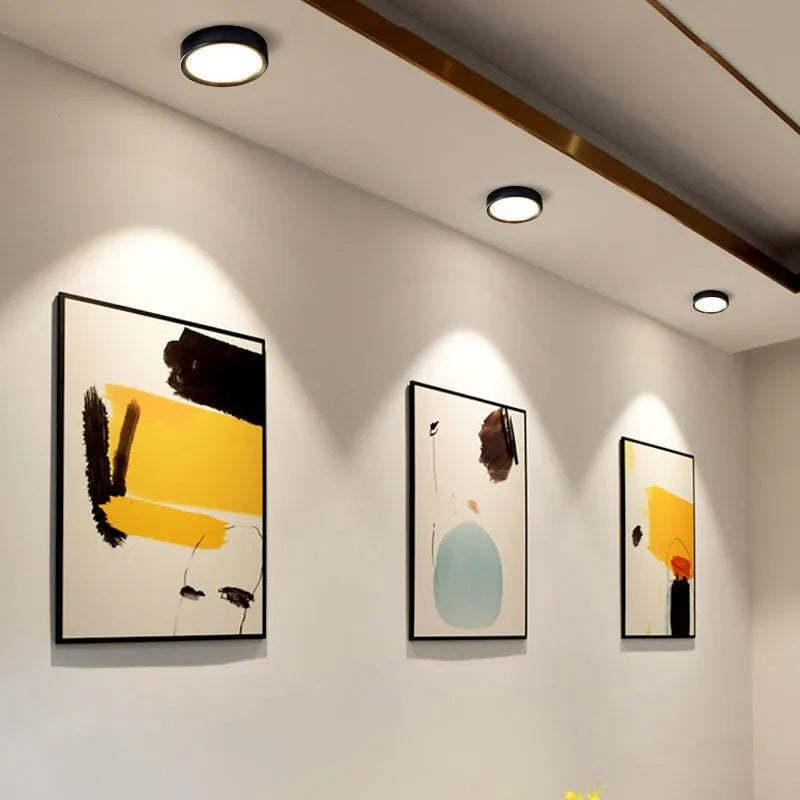 Ultra-thin surface mounted LED downlight in a choice of seven shell colours including black, white, gold, and pink.