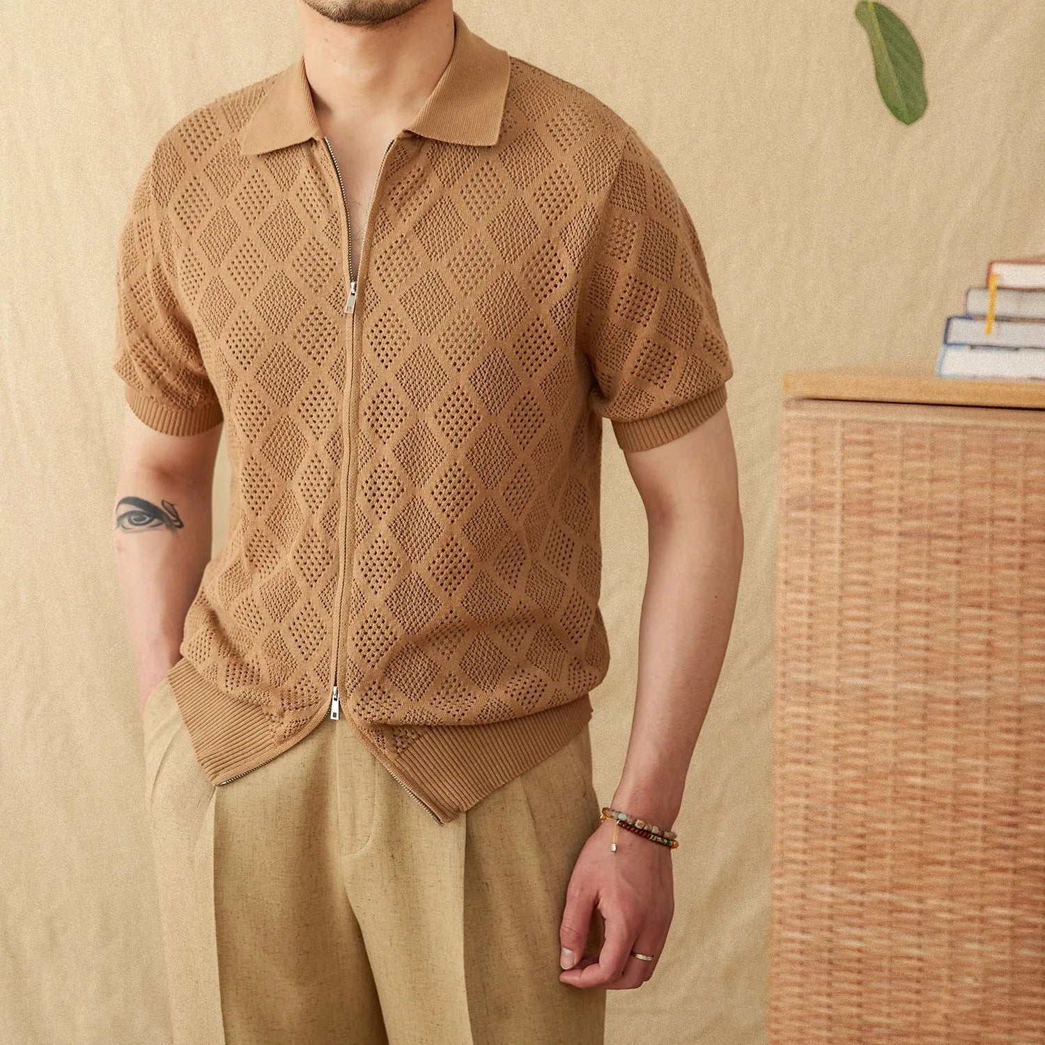 Man wearing a light brown zip-front cotton cardigan with short sleeves and a lapel collar.