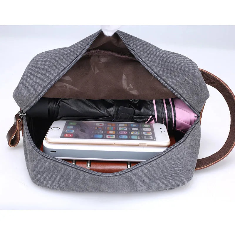 Men's canvas changing wallet in horizontal square shape with soft carry handle and zippered compartments, available in five solid colours.
