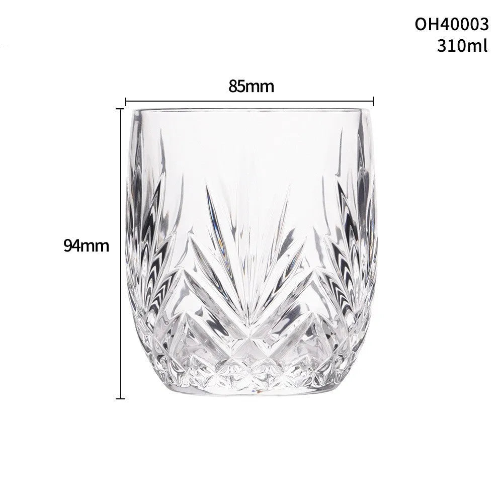 Clear crystal whiskey shot glass with thick bottom base on a table.