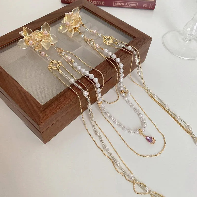Gold-coloured women's hairpin with acrylic flower design featuring pearl, diamond, and long tassel decorative elements